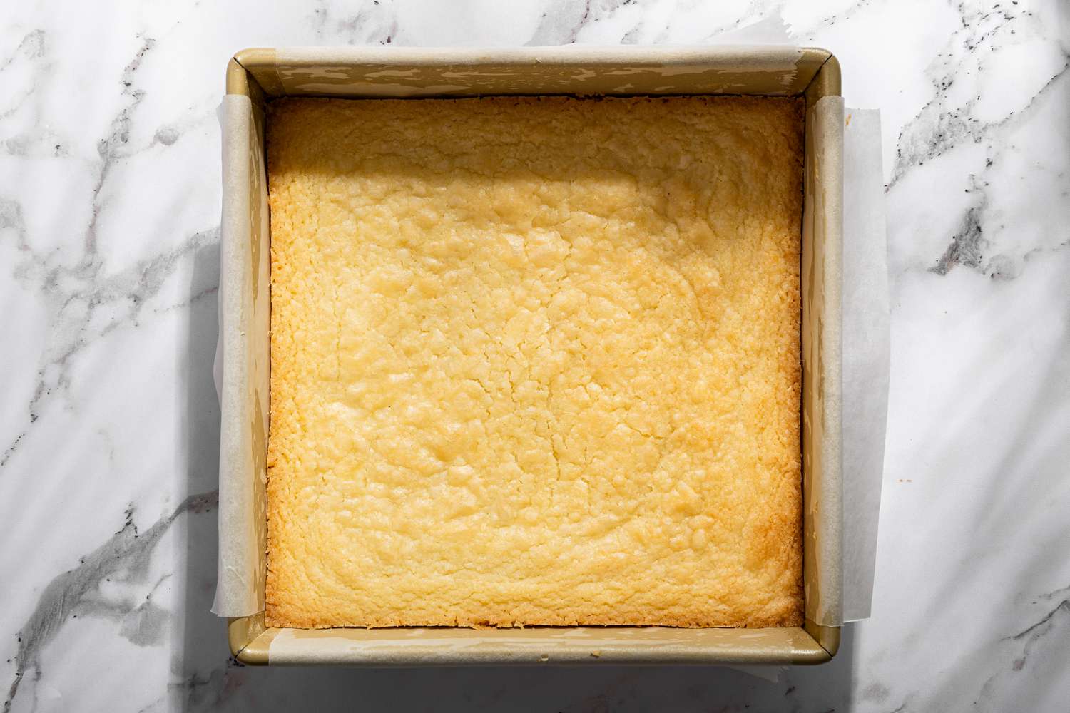 Overhead view of a baking pan with the baked shortbread for Millionaire Shortbread recipe 