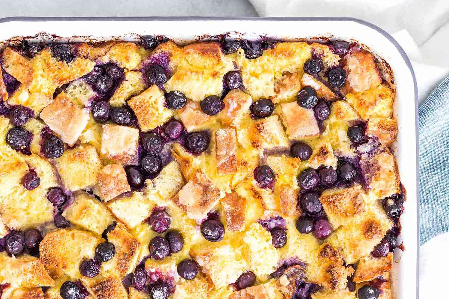 A close up of a french toast casserole bake with blueberries