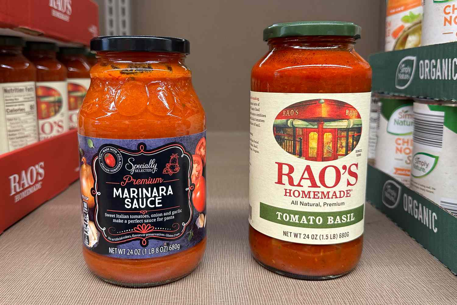 Specially selected marinara sauce jar next to a rao's homemade tomato basil sauce jar on the store shelves