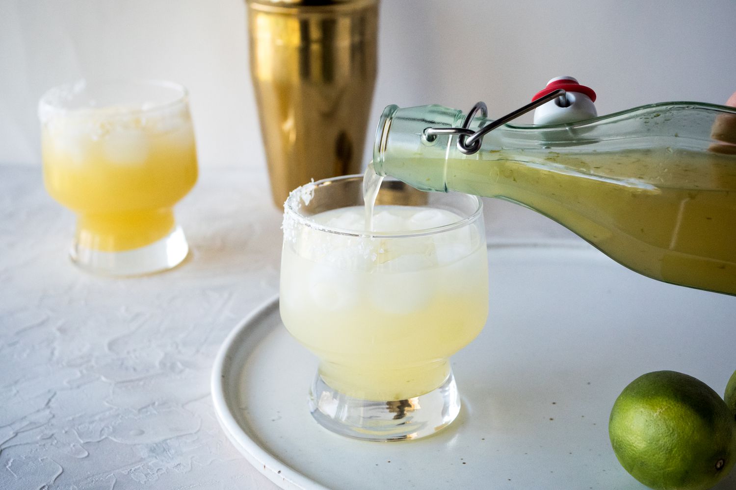 The BEST margarita mix recipe poured into a glass with ice to make a margarita.