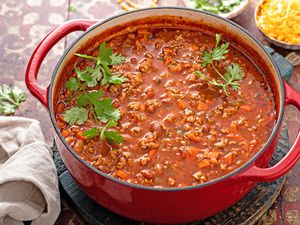 A pot of chili with cilantro garnish on top