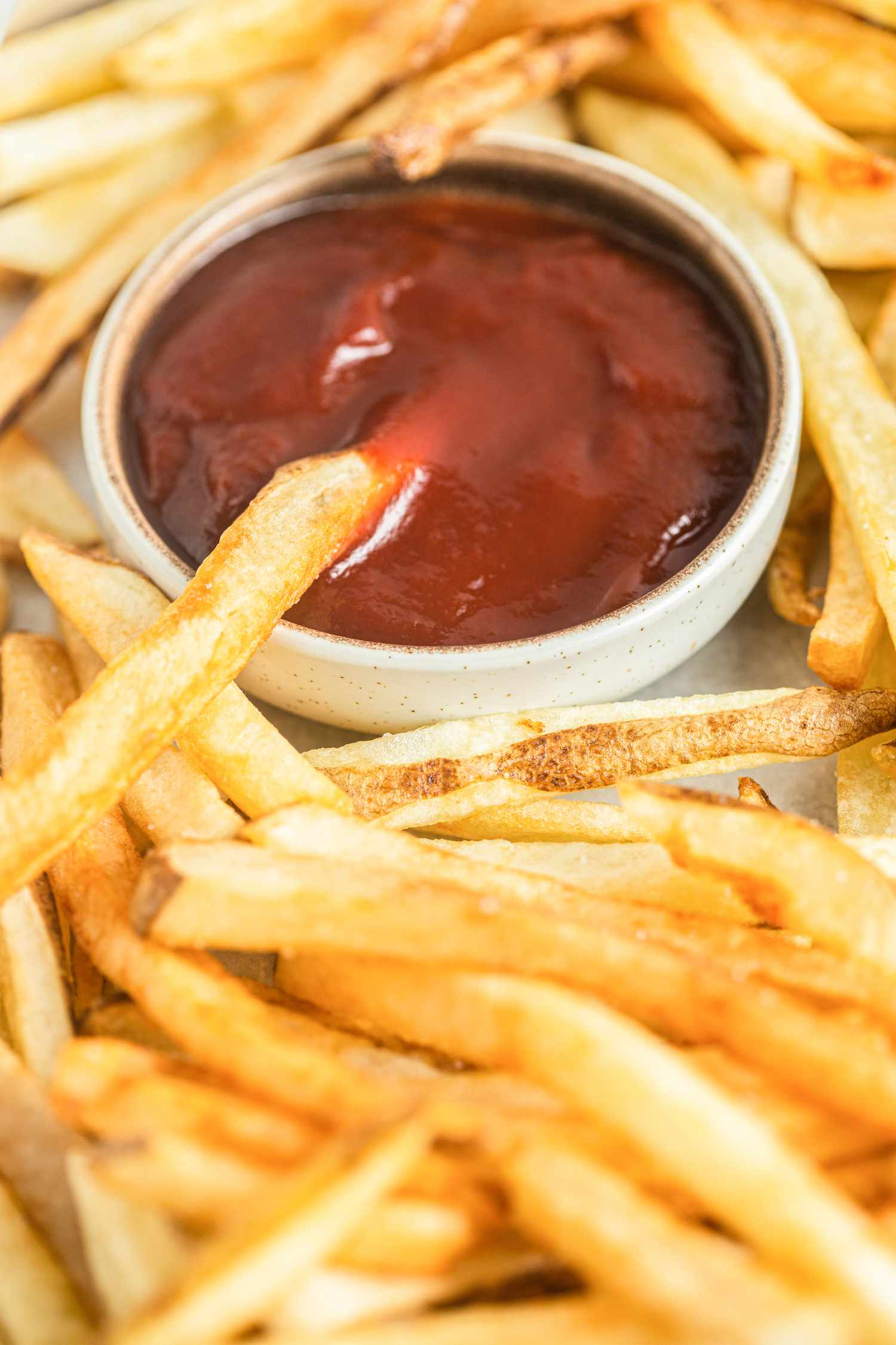 Homemade French Fries Served with Ketchup with One Fry Dipped in the Ketchup