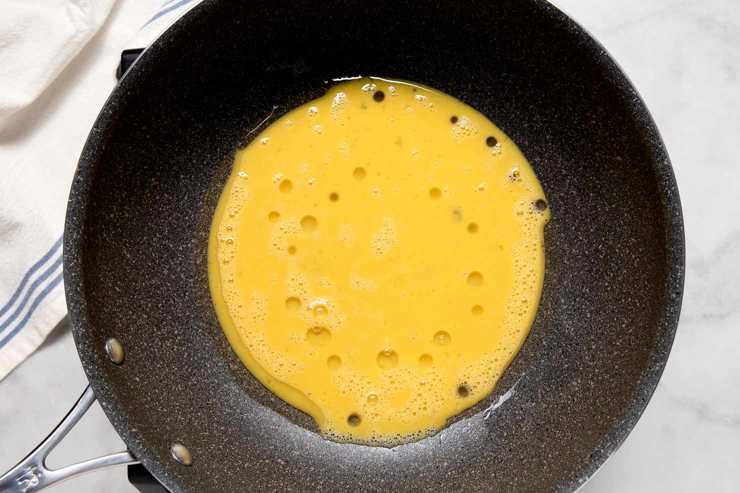 Raw eggs poured into a nonstick pan