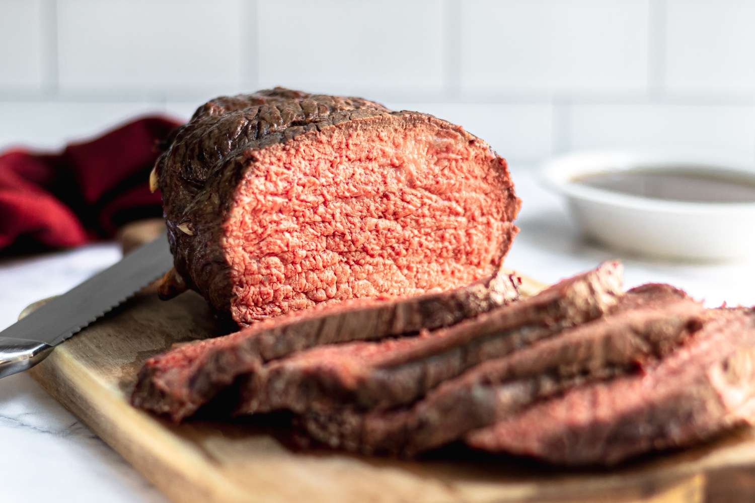 Sliced roast beef cooked to medium rare beef temperature on a cutting board