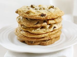 A stack of chocolate chip cookies on a white plate
