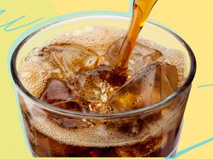 Close up of Coke being poured into a glass with ice