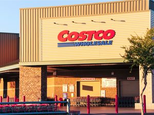 The exterior of a Costco Wholesale store with visible entrance and shopping carts in front