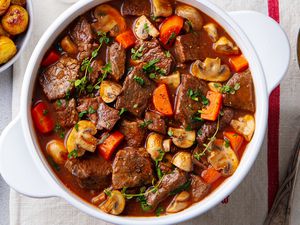 A white serving bowl with beef stew