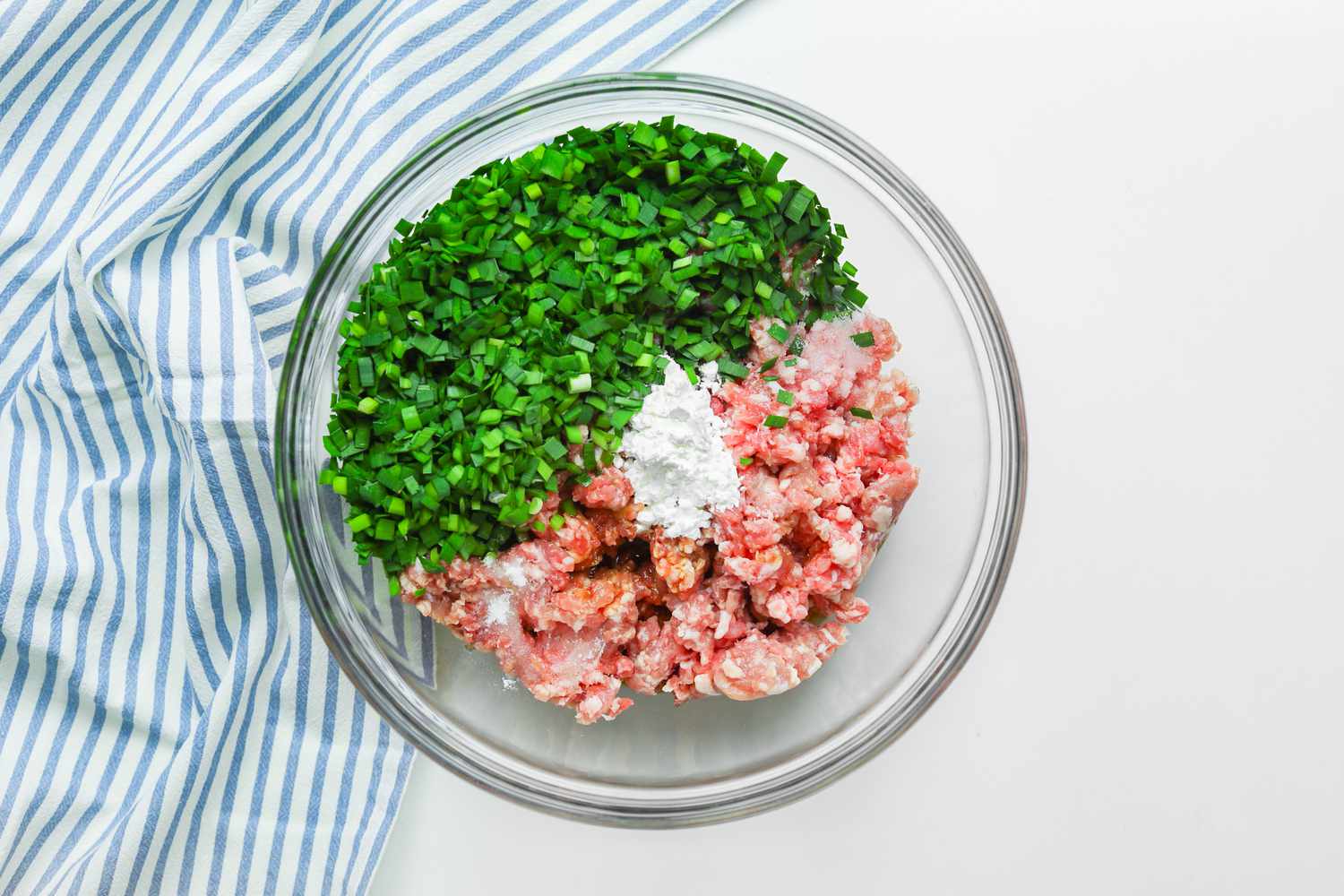 Bowl of Ground Pork, Chopped Chives, Cornstarch, and Seasoning for Pork and Chive Dumpling Recipe