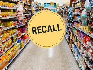 Supermarket aisle with a large recall notice in yellow