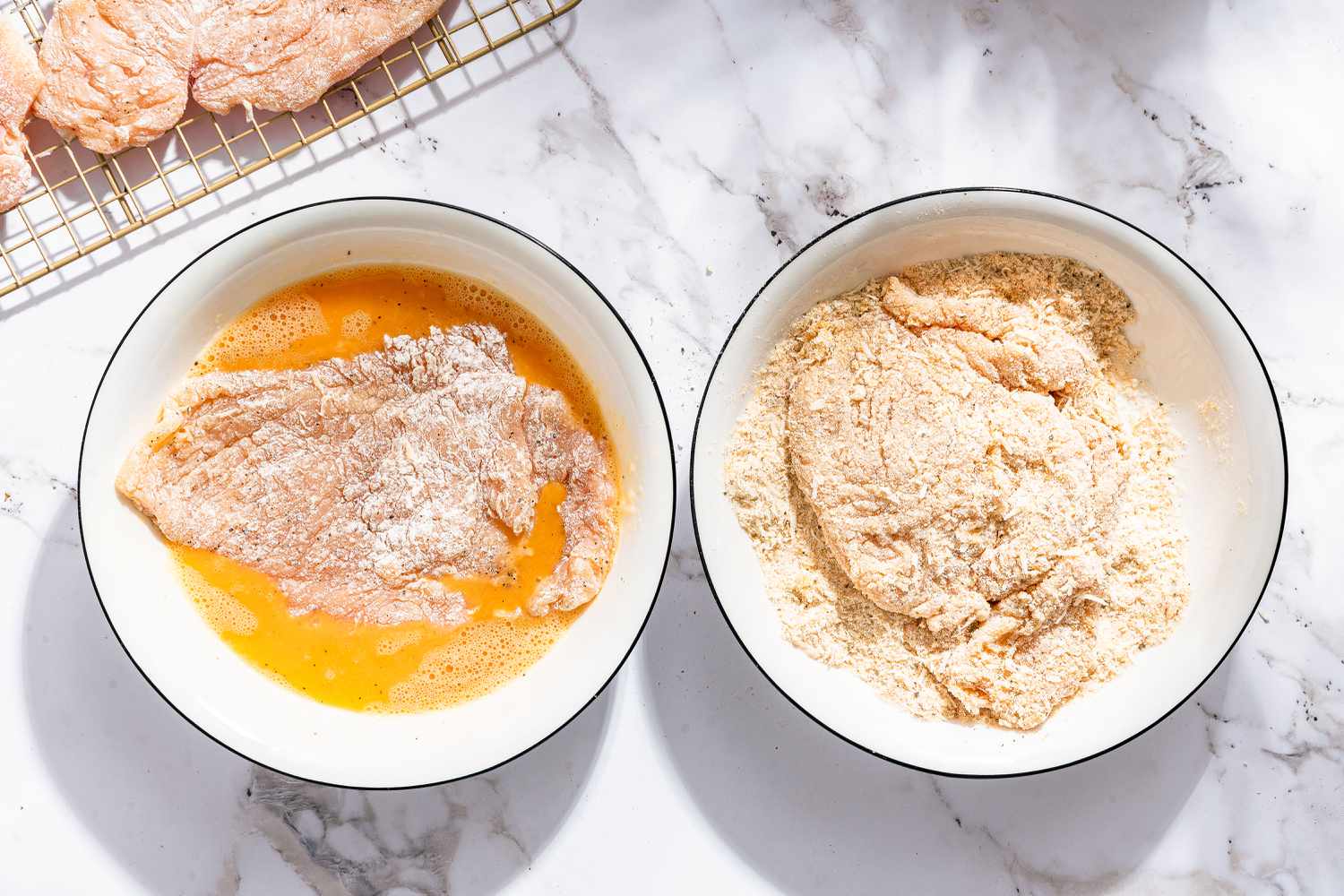 flour dusted chicken cutlet in egg mixture bowl, another cutlet in the breadcrumb bowl and covered with breadcrumbs for Chicken Romano 