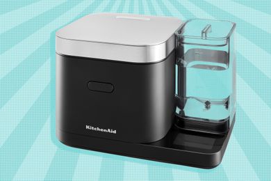 A black square rice cooker with a silver top and a clear water reservoir on the right side.