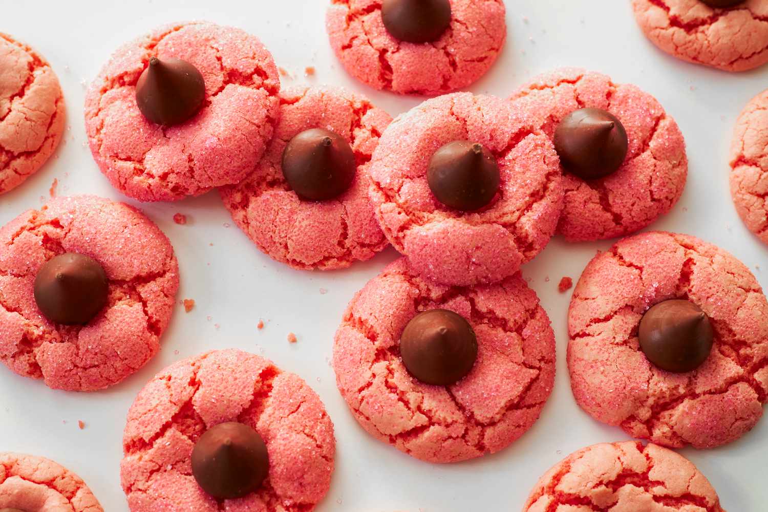 Overhead view of strawberry chocolate kiss cookies on a white background