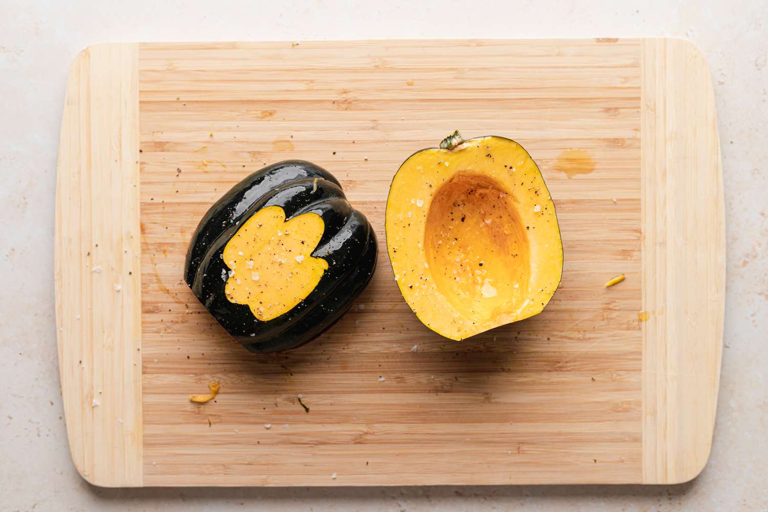 Making vegetarian stuffed squash and cutting a squash in half and scooping out the seeds.