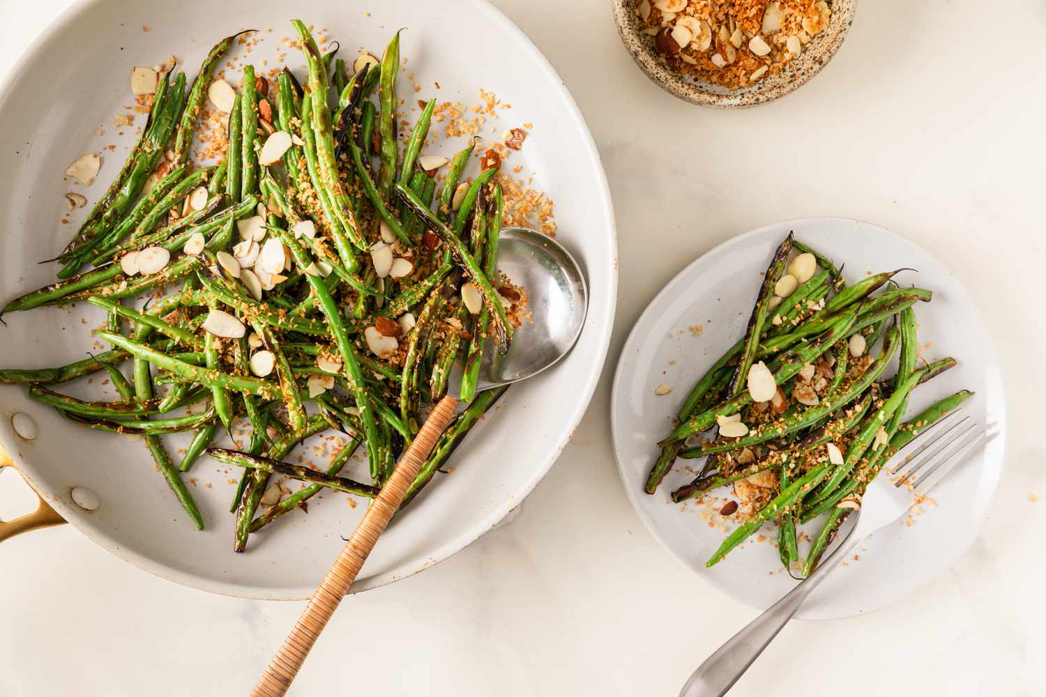 Broiled green beans plated with toasted almonds and crispy topping