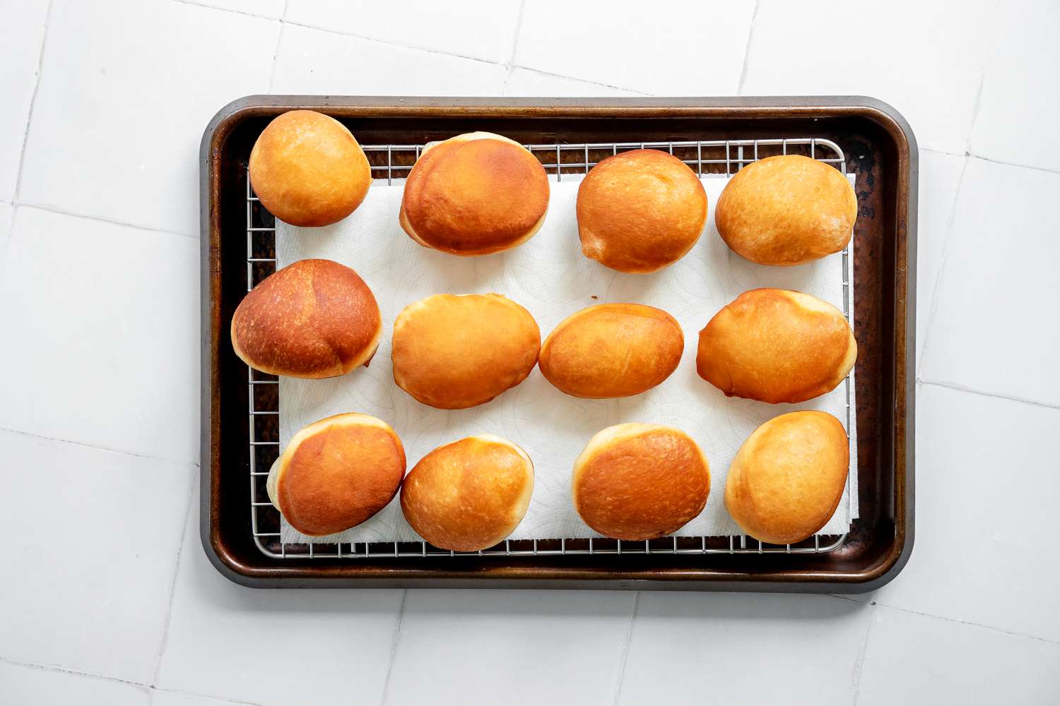 Fried Sufganiyot (Israeli Jelly Donuts) Placed on a Paper Towel Lined Cooling Rack on a Baking Sheet