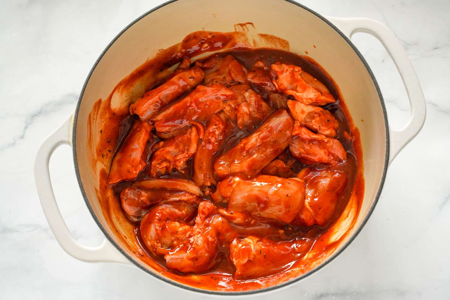 Boneless, Skinless Chicken Thigh Mixed With the BBQ Sauce in the Dutch Oven