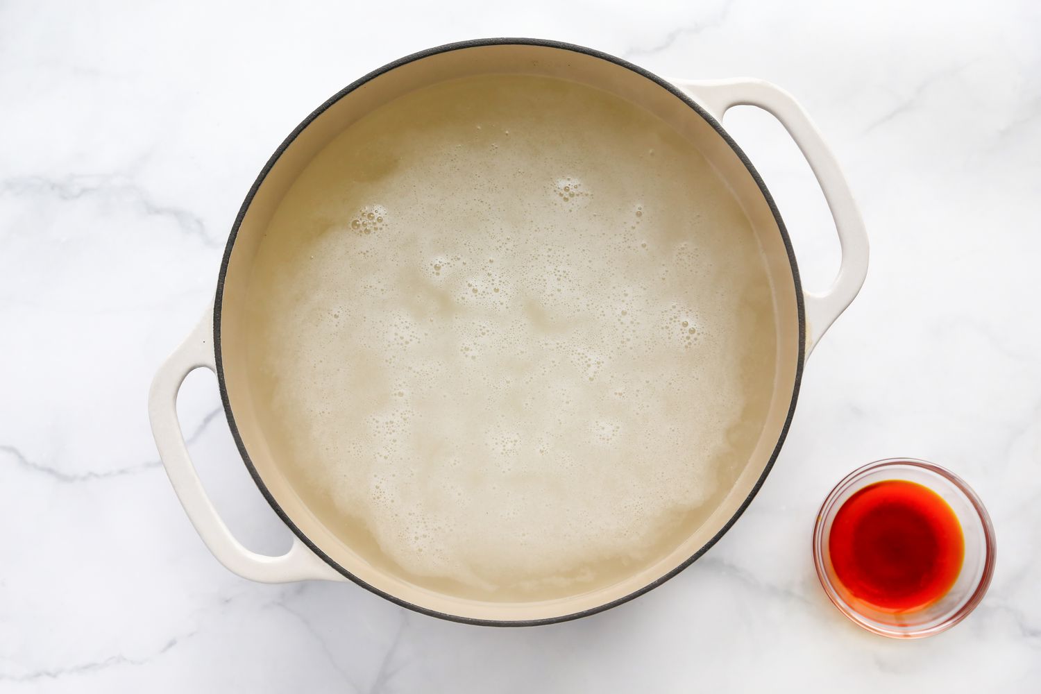 Rice Boiling in a Dutch Oven Next to the Bowl of Saffron Water