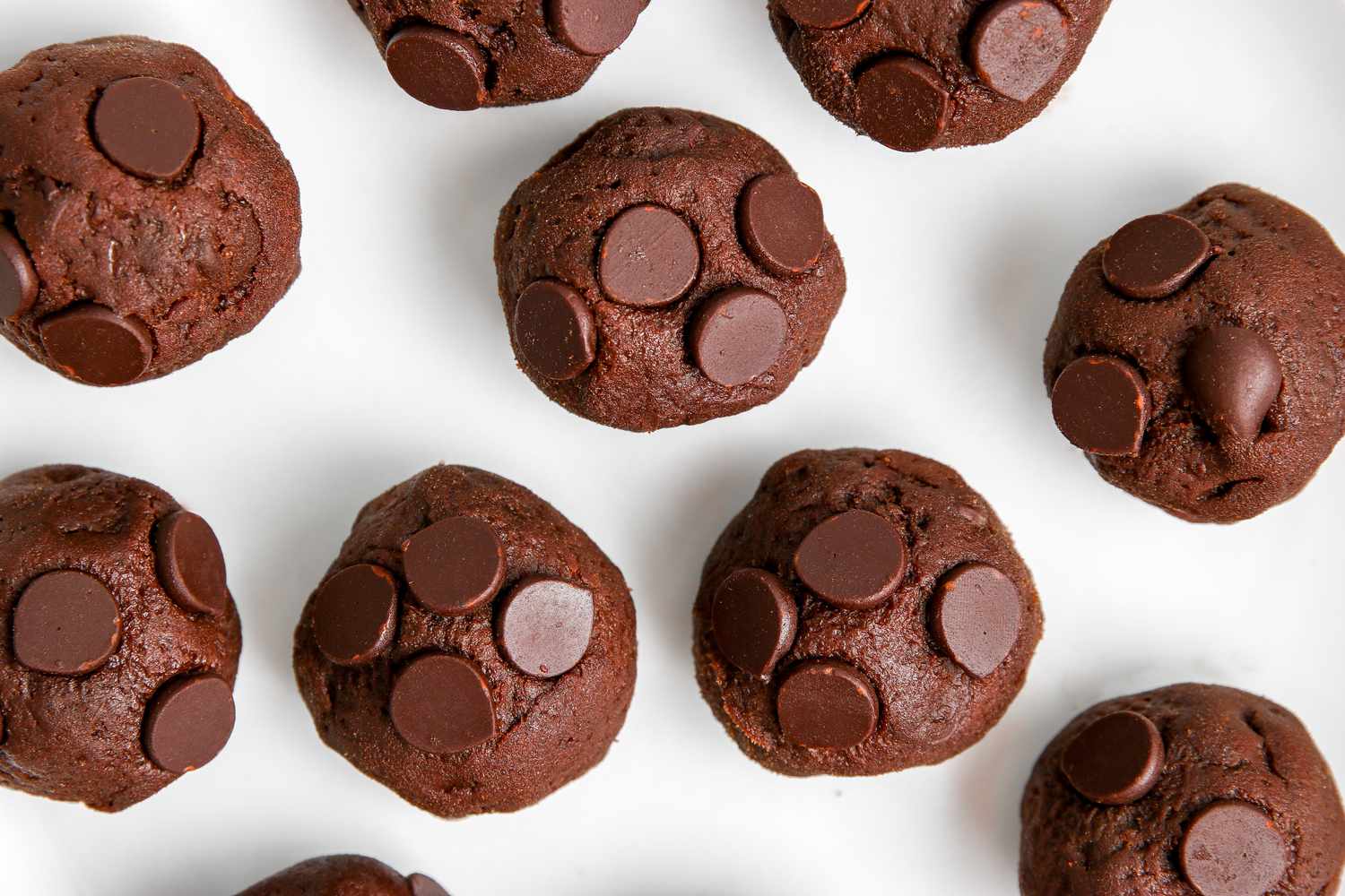 Easy chocolate chocolate cookies rolled into balls and set on a baking sheet.