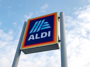 An Aldi storefront sign with a clear sky background