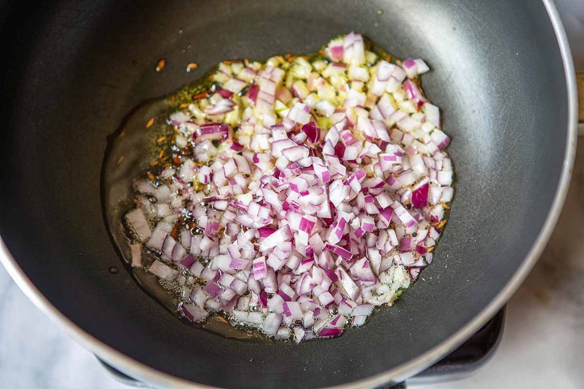 Vegan Chana Masala - oil, onions, spices, in pan