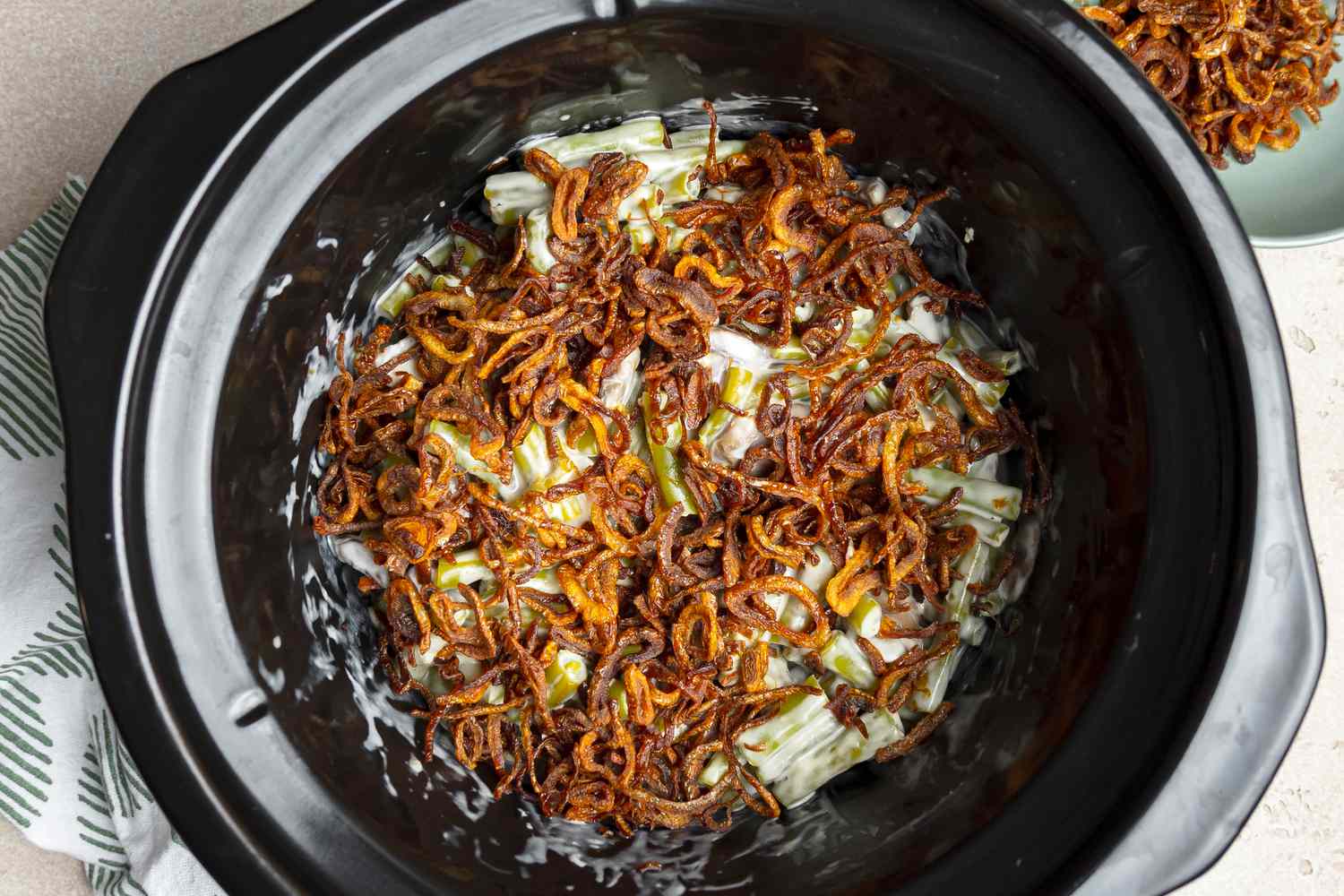 Green Bean Casserole in a Slow Cooker Topped with Crispy Shallots