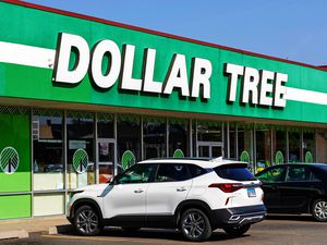 Exterior of a Dollar Tree retail store with parked vehicles in front, showing the store's signage prominently