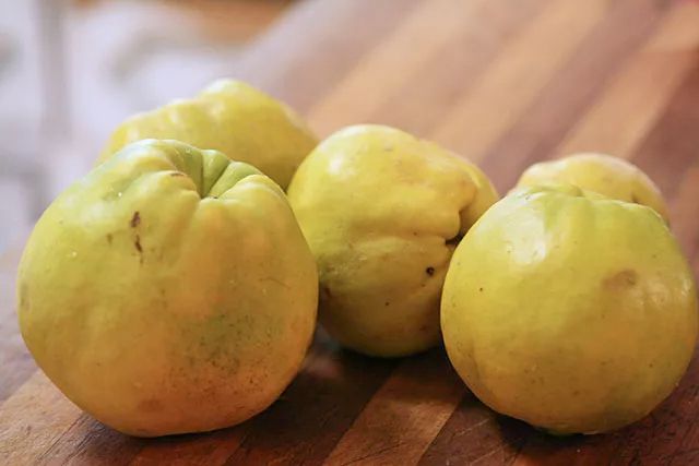 Four whole quince on a cutting board