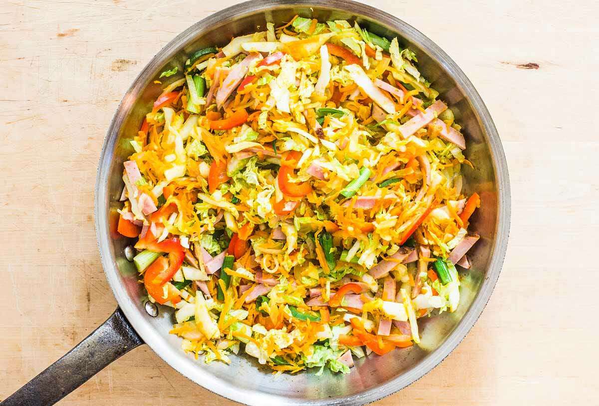 combine together the noodles, eggs, and vegetables for Singapore Street Noodles