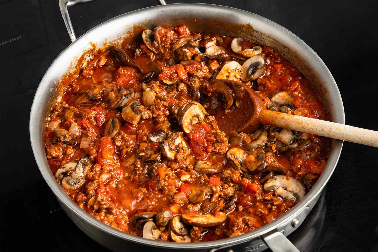 Cooked mushrooms added to the meat sauce in the skillet for Johnny Marzetti casserole recipe