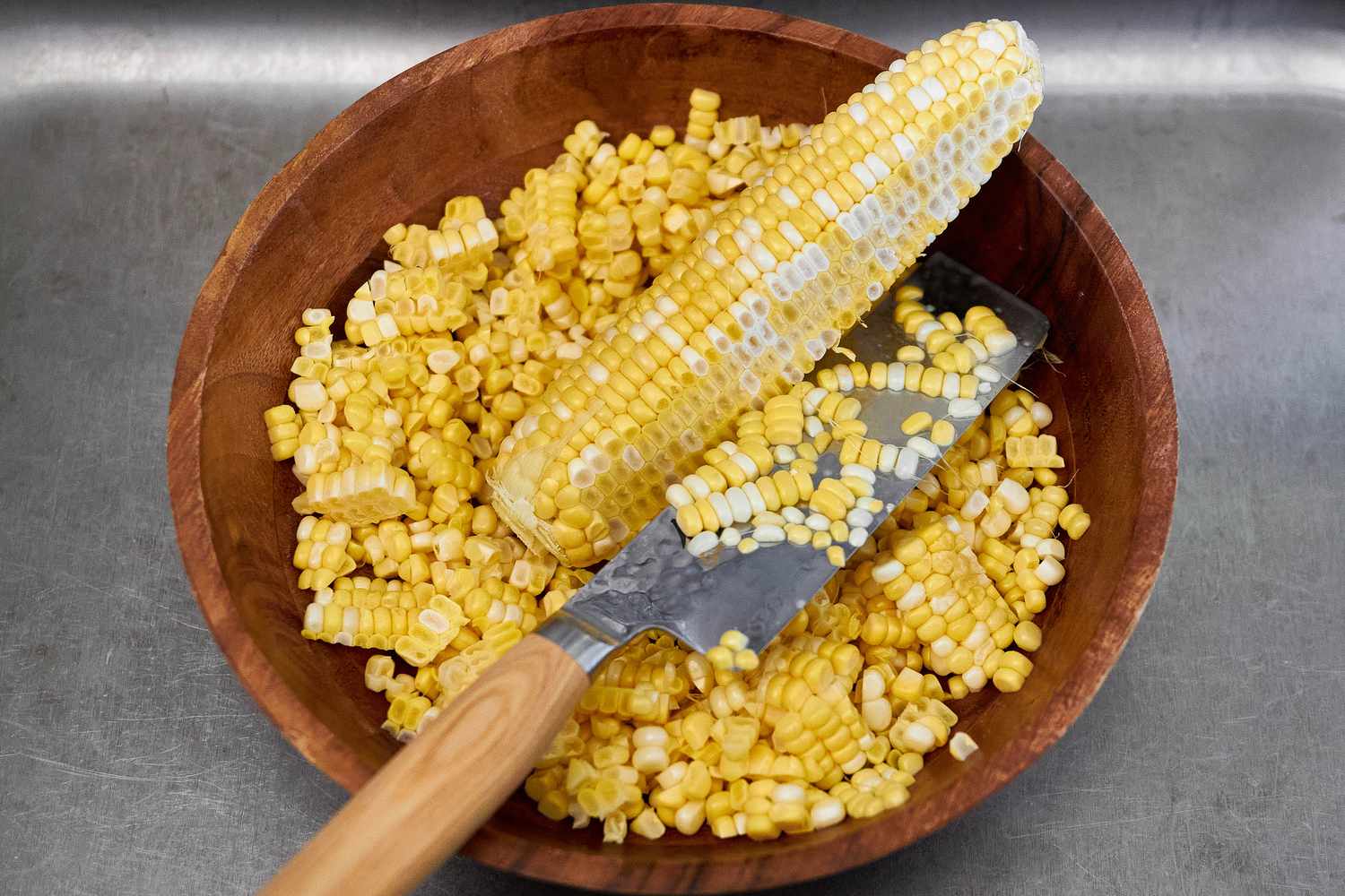 An Ear of Fresh Corn With Some of the Kernels Sliced Off in a Bowl With More Fresh Kernels and a Knife Korean Cheese Corn Recipe