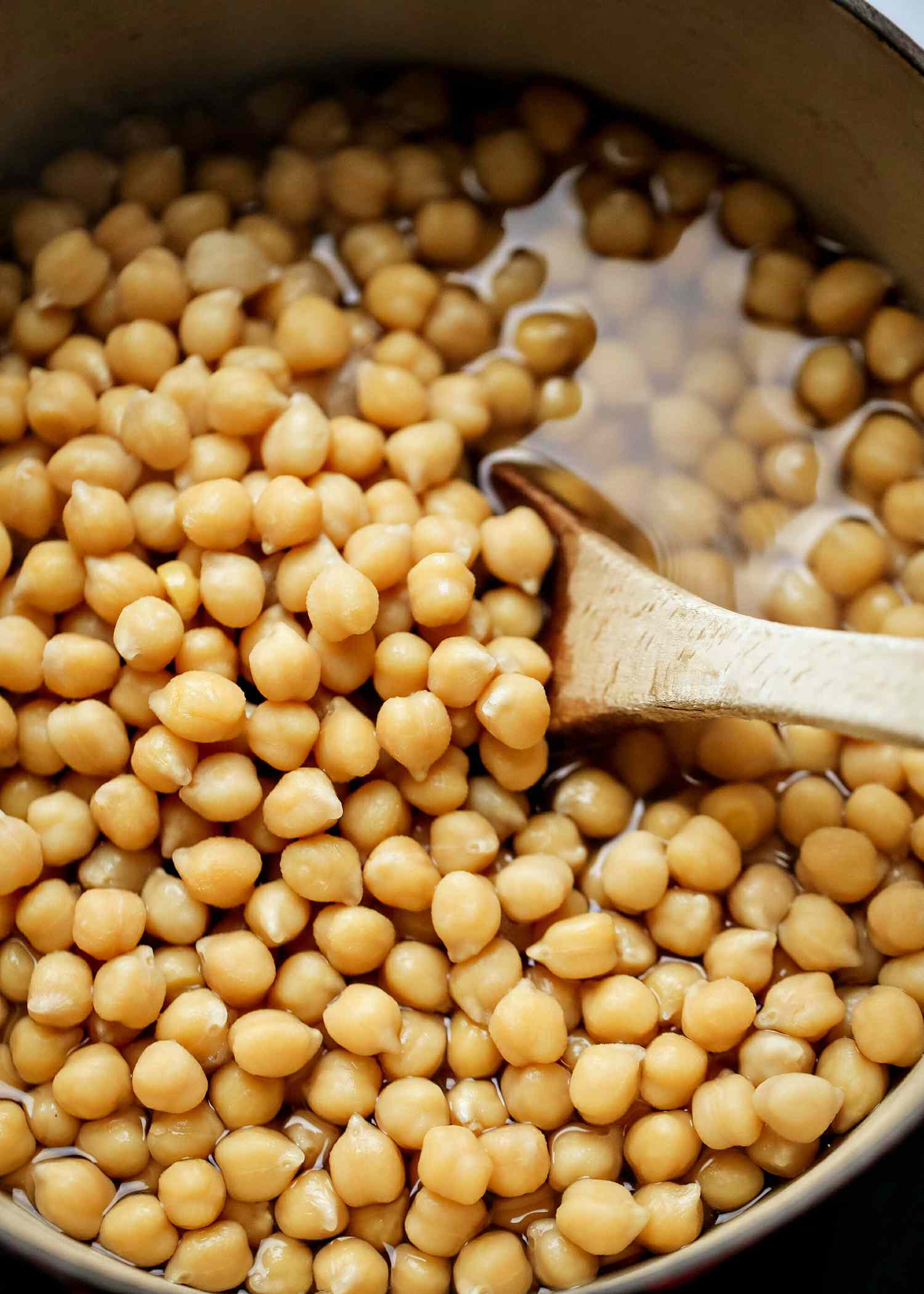 Chickpeas in a Dutch oven with a wooden spoon