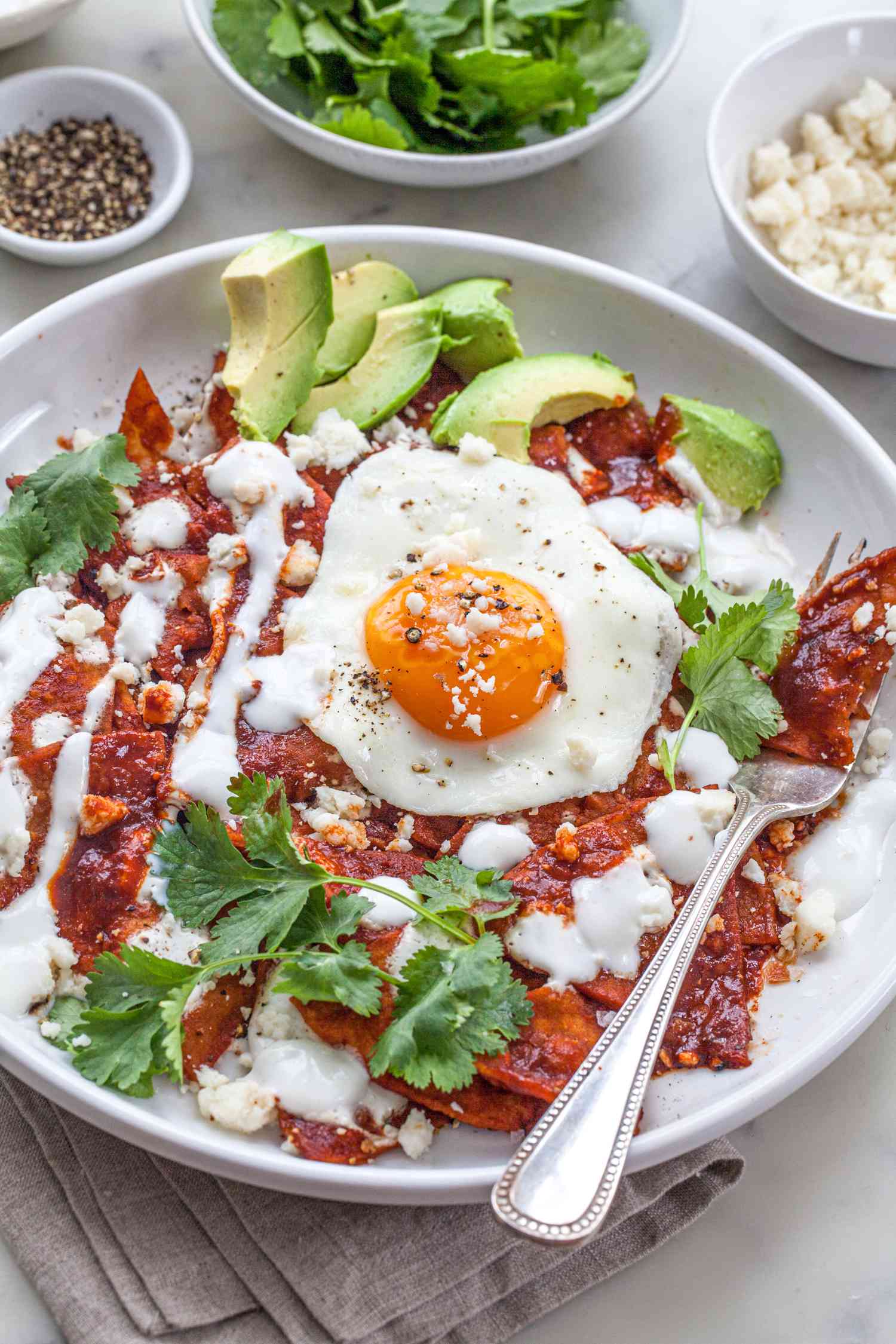 Chilaquiles on a white plate with a fork