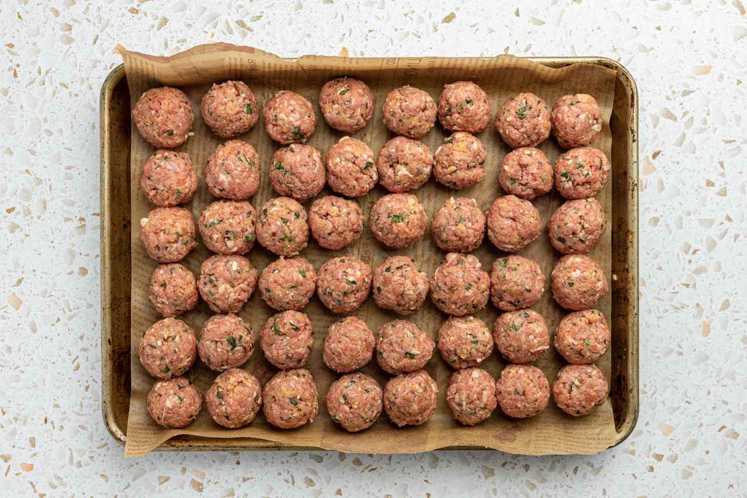 Meatballs on a Parchment Paper Lined Baking Sheet after Being Shaped into Balls for Spaghetti and Meatballs Recipe