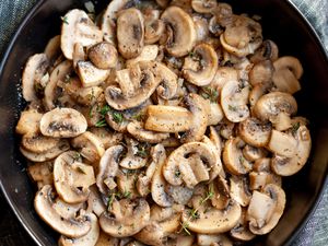 A bowl of sauted sliced mushrooms with herbs