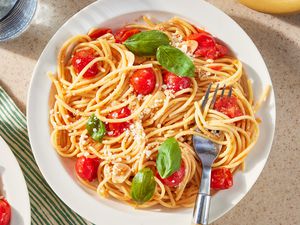 plateful of pasta with cherry tomatoes and basil leaves