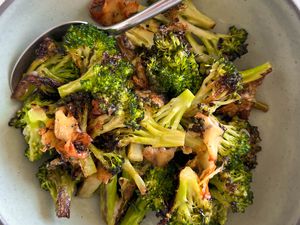 Cheesy Broccoli in a neutral bowl with a spoon